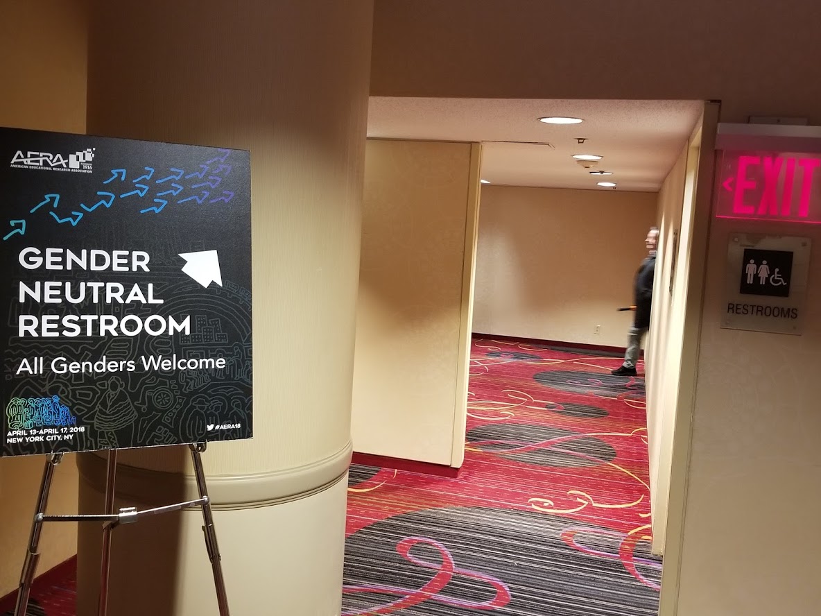 gender-neutral restroom sign, next to gendered restroom sign
